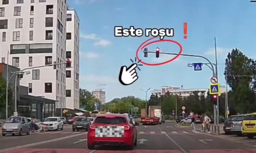 Red traffic light circled with the Romanian caption 'Este rosu' and a pointing hand for emphasis at a city intersection.