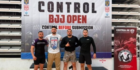 Four men stand on a winners podium in front of a banner that reads 'CONTROL BJJ OPEN', posing for a photo at a martial arts event.